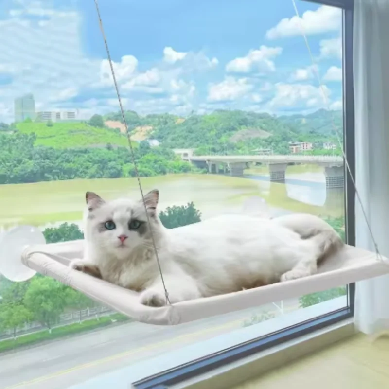 White cat lying on a suction cup cat window hammock held by steel cables