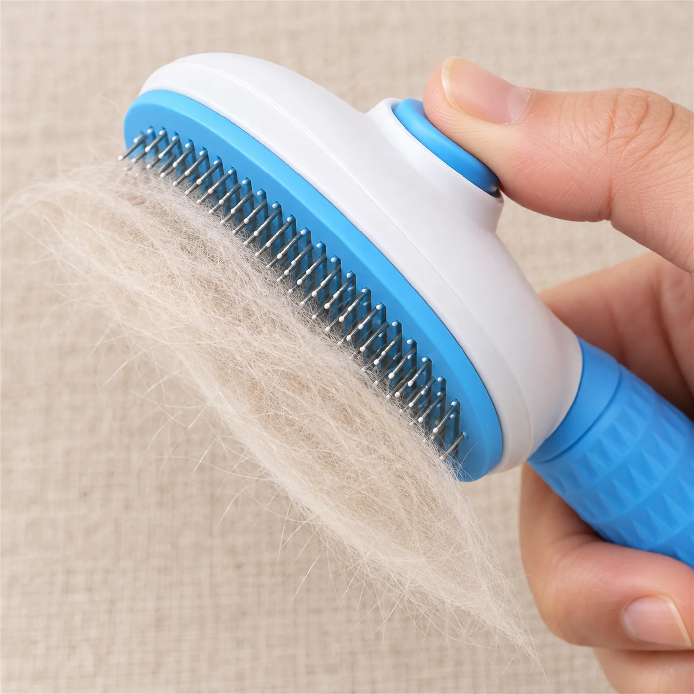 Pressing the button on the blue self-cleaning brush to release the fur